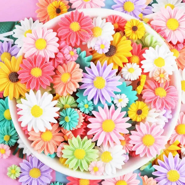 A colorful assortment of pink, yellow, and white sunflower flatback resin cabochons for crafts