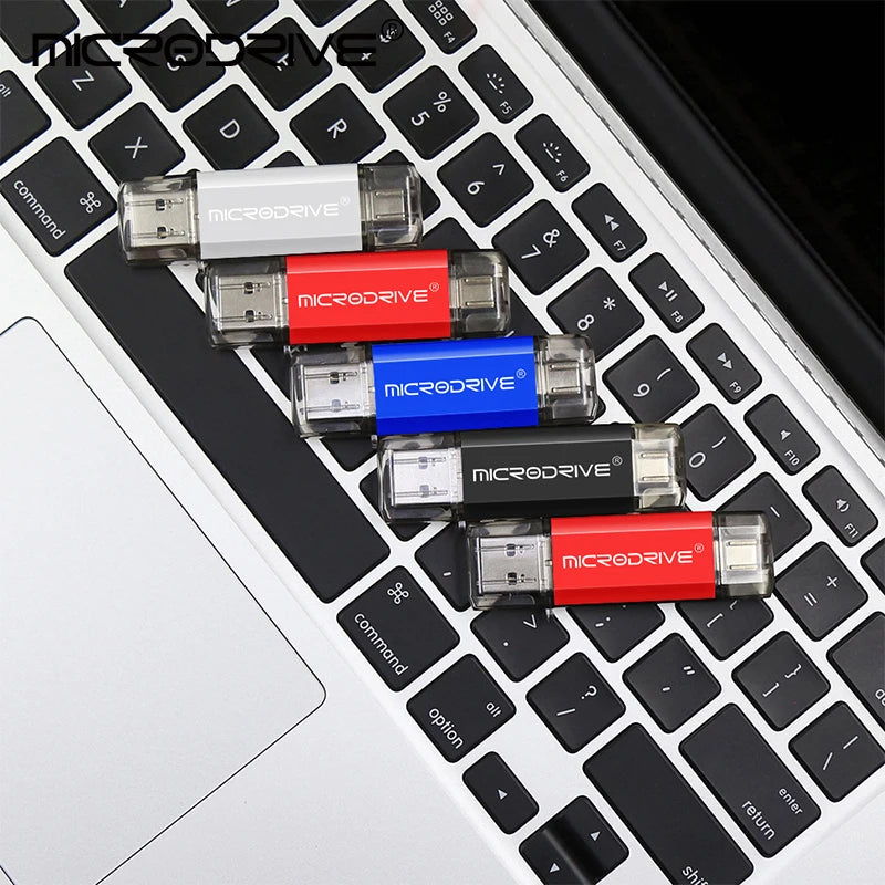مجموعة من محركات فلاش MicroDrive بألوان مختلفة تستقر على لوحة مفاتيح حاسوب محمول.