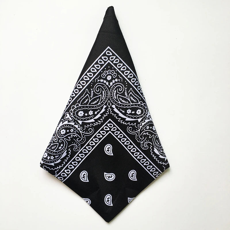 Black bandana square scarf with white paisley print folded into a triangle shape