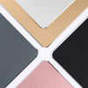 A collection of mouse pads in various colors including beige, light gray, black, and pink.