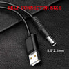 Cable universal negro para carga DC con punta de conector de 5.5x2.1mm sobre una superficie oscura.