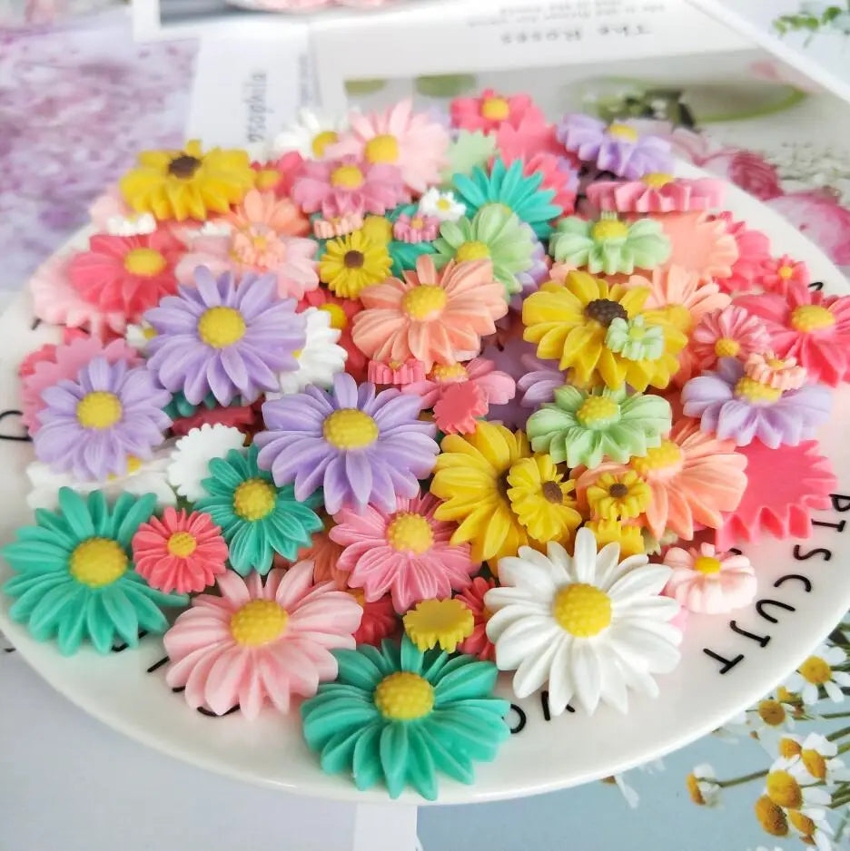 A colorful arrangement of pink, yellow, purple, and green sunflower resin cabochons for crafts