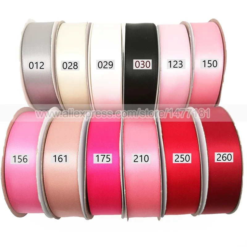 Rollen doppelseitiger Satinband in verschiedenen Farben, darunter rosa, beige, schwarz und rot.