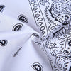 White fabric with a black paisley print folded to show the pattern detail.
