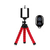 A flexible mini tripod with a black clip and red legs is shown against a white background.