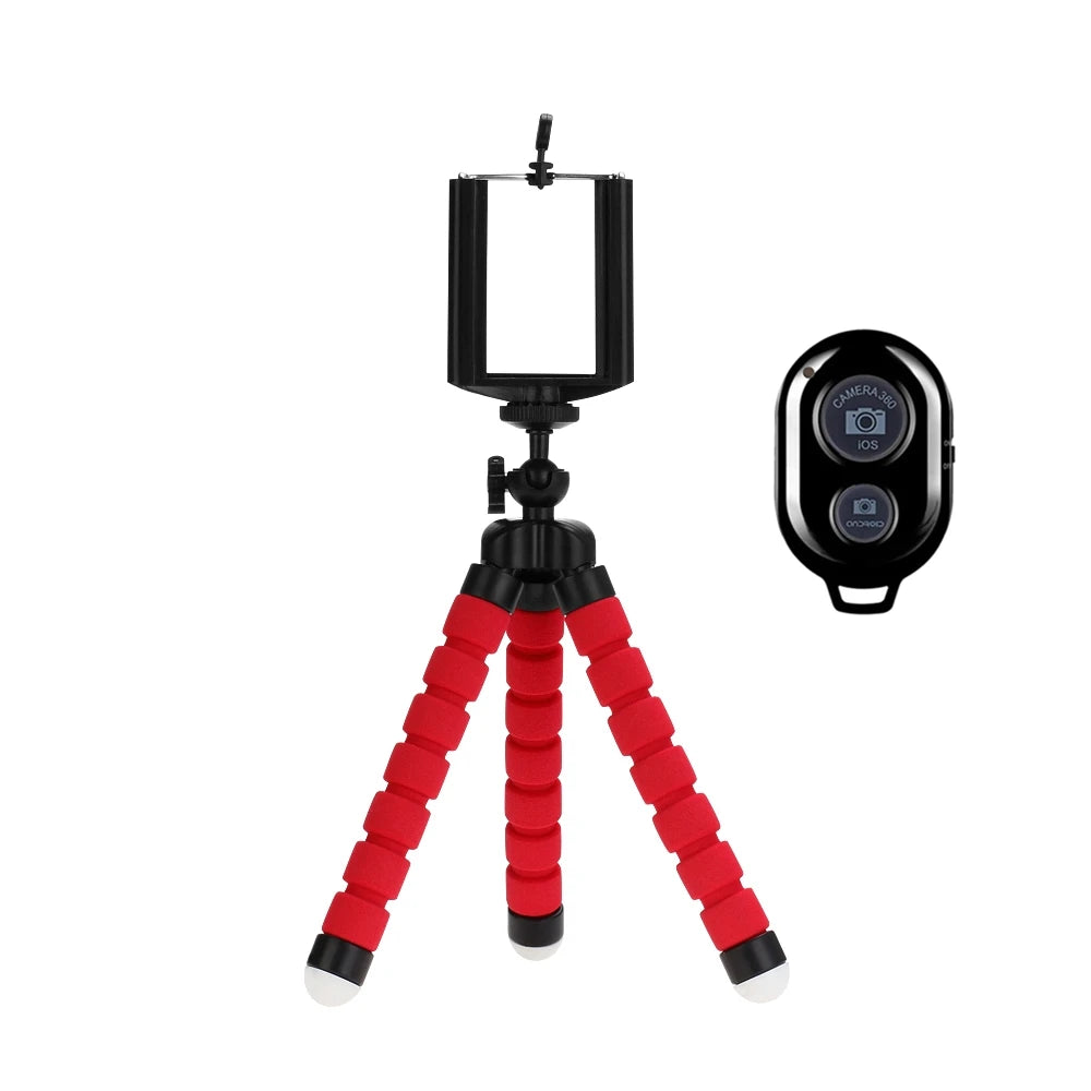 A flexible mini tripod with a black clip and red legs is shown against a white background.