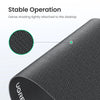 Close-up view of a black non-slip rubber mouse pad with dense shading tightly attached to the desktop.