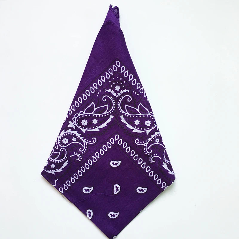 A purple cotton bandana square scarf featuring a white paisley print.