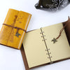 A vintage butterfly PU leather A6 journal notebook with a brown leather tie and a decorative clasp.