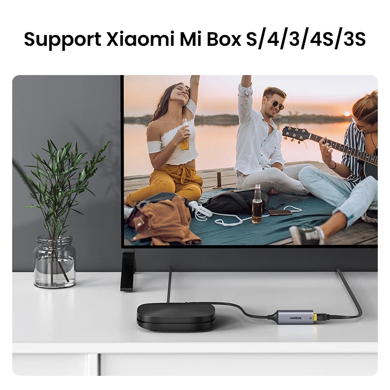 A USB to Ethernet adapter is shown next to a laptop, with a background featuring people enjoying the sunset.