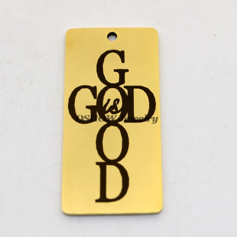 A gold-colored stainless steel rectangle charm pendant engraved with the words God Is Good in a cross design.