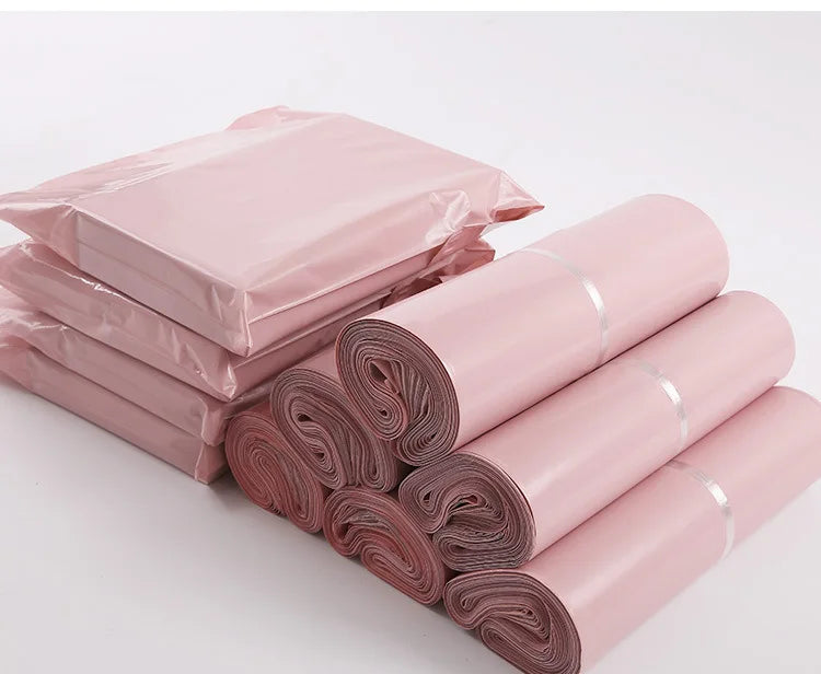 Pink waterproof self-seal poly mail bags stacked and rolled for sale