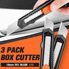 A hand is using a black box cutter with orange handles to cut a piece of paper, showing three packs of 18mm SK5 blades.