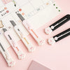 A collection of pink and black portable pet claw tools or knives laid on a calendar page.
