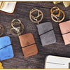 Eine Sammlung von Gold- und Roségold-PU-Leder-Journal-Anhängern und einem Notizbuch auf einer dunklen Holzoberfläche.