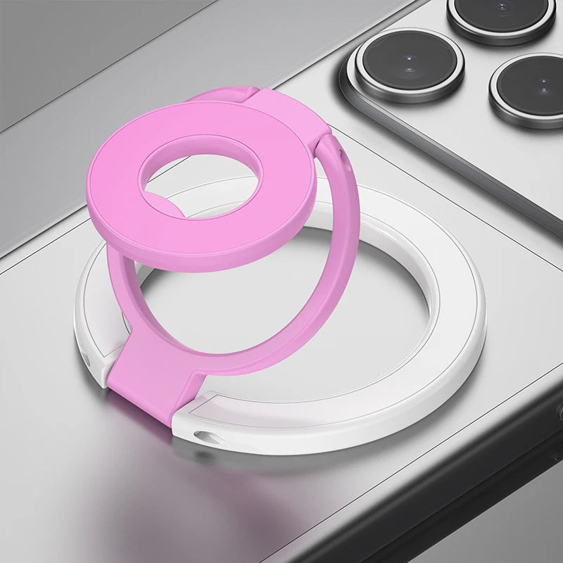 A pink MagSafe double-sided phone ring holder stand resting on a gray surface.