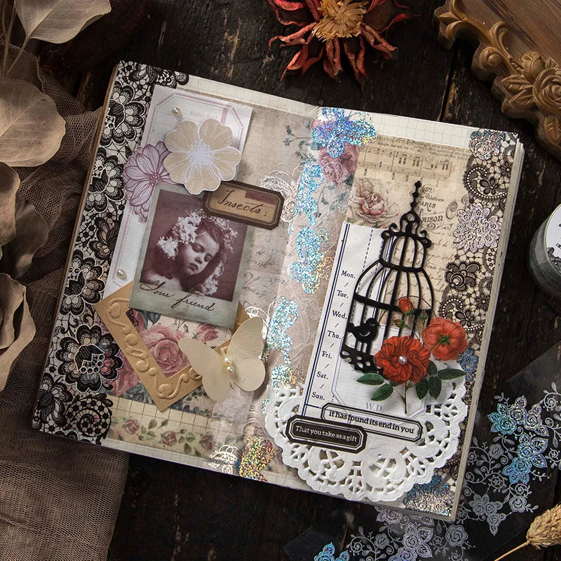 A handmade paper craft featuring floral and nature elements with silver stamping lace tape on a rustic background.