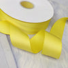 Yellow matte finish satin ribbon rolled on a white core, shown in a close-up.