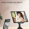 A foldable desktop phone stand is shown supporting a smartphone on a wooden table.