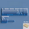 A box pack of PBT double-shot cherry profile keycaps for mechanical keyboards arranged on a blue surface.