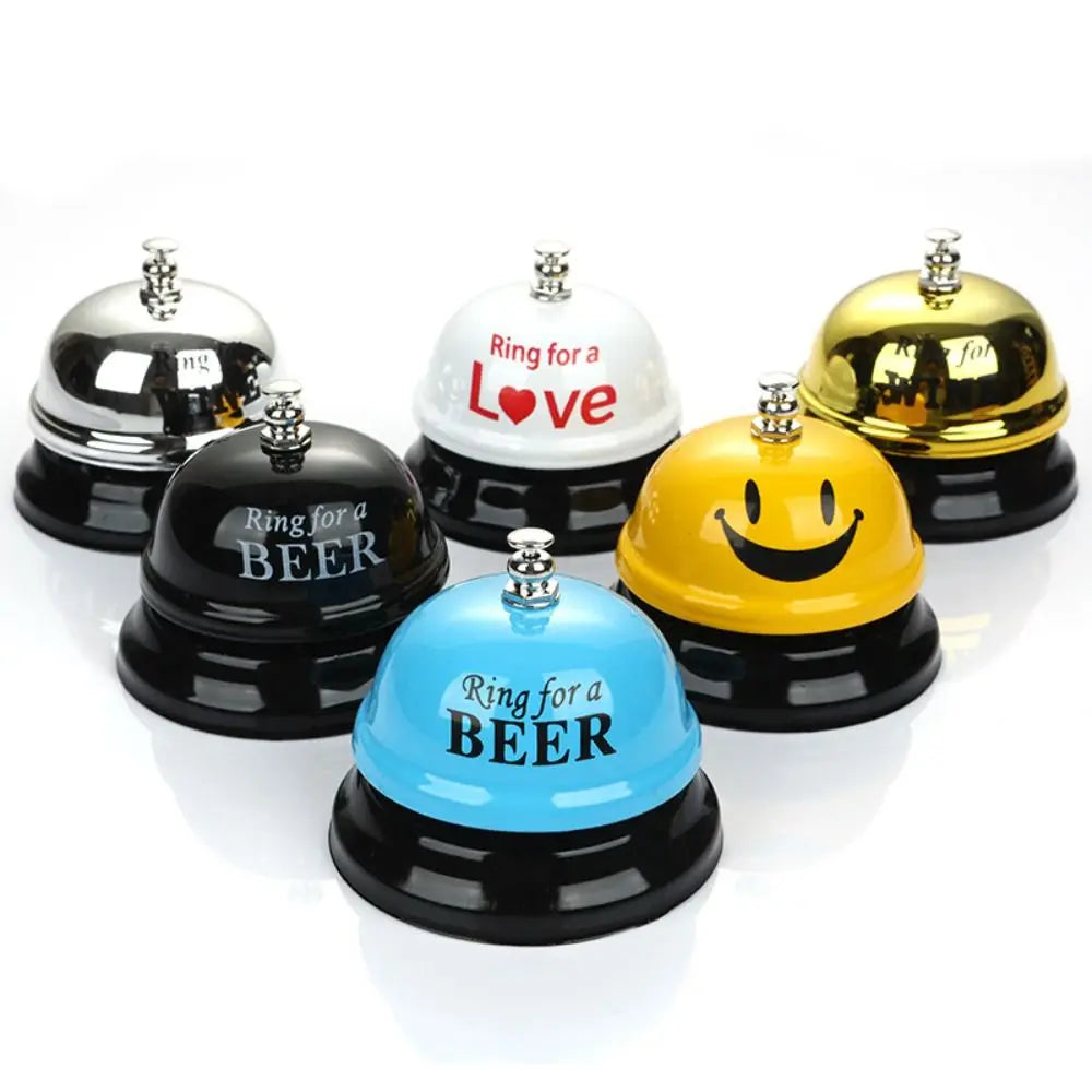 A set of classic metal service bells in silver, gold, and black with a heart design for desk or counter use.