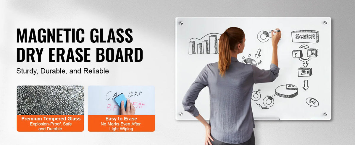 A woman writes on a magnetic glass dry erase board showing various diagrams and graphs.