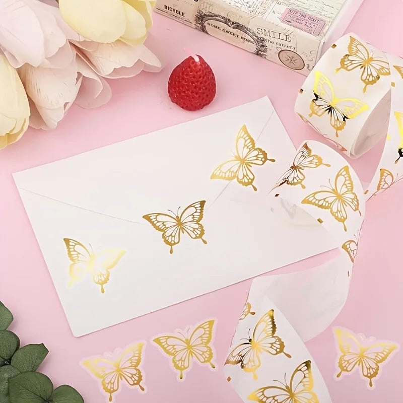A white envelope decorated with golden butterfly stickers on a pink background.