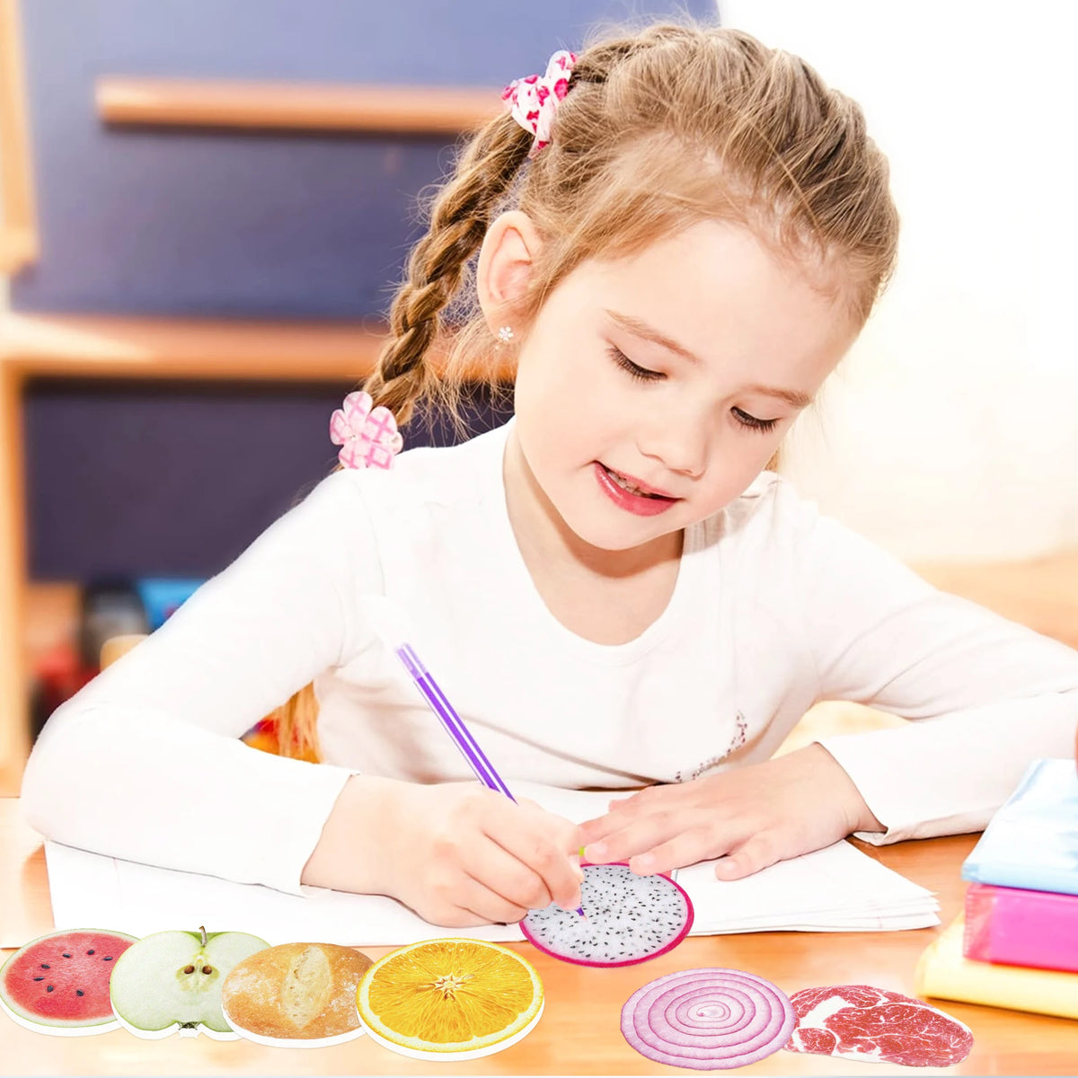 A young girl is writing on paper with a purple pen next to a set of fruit-shaped sticky notes.