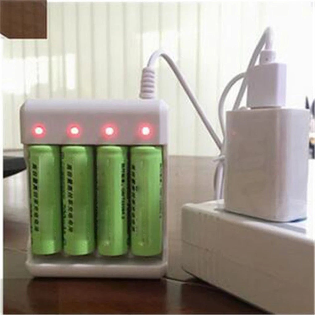 A white battery charger device with four green cells is shown next to a white power adapter.
