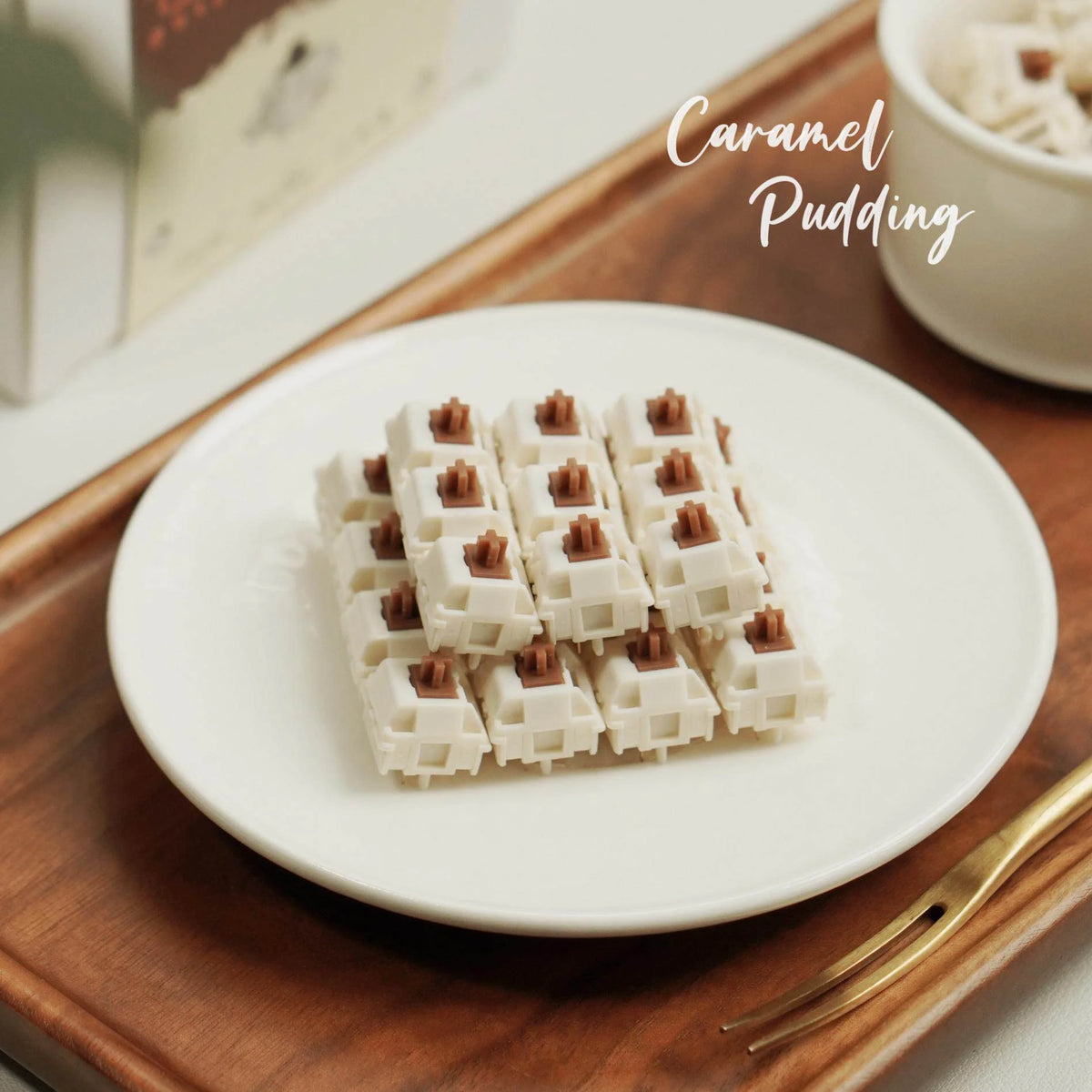 Teller mit Karamellpudding, weiße und braune rechteckige Lebensmittel auf Holzbrett.