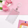 A clear acrylic card holder with a decorative border and a silver keychain ring, set against a pink background with tulips.