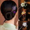 Gros plan sur les cheveux noirs d'une femme, coiffés en chignon avec des accessoires floraux en bois de style chinois rétro, 