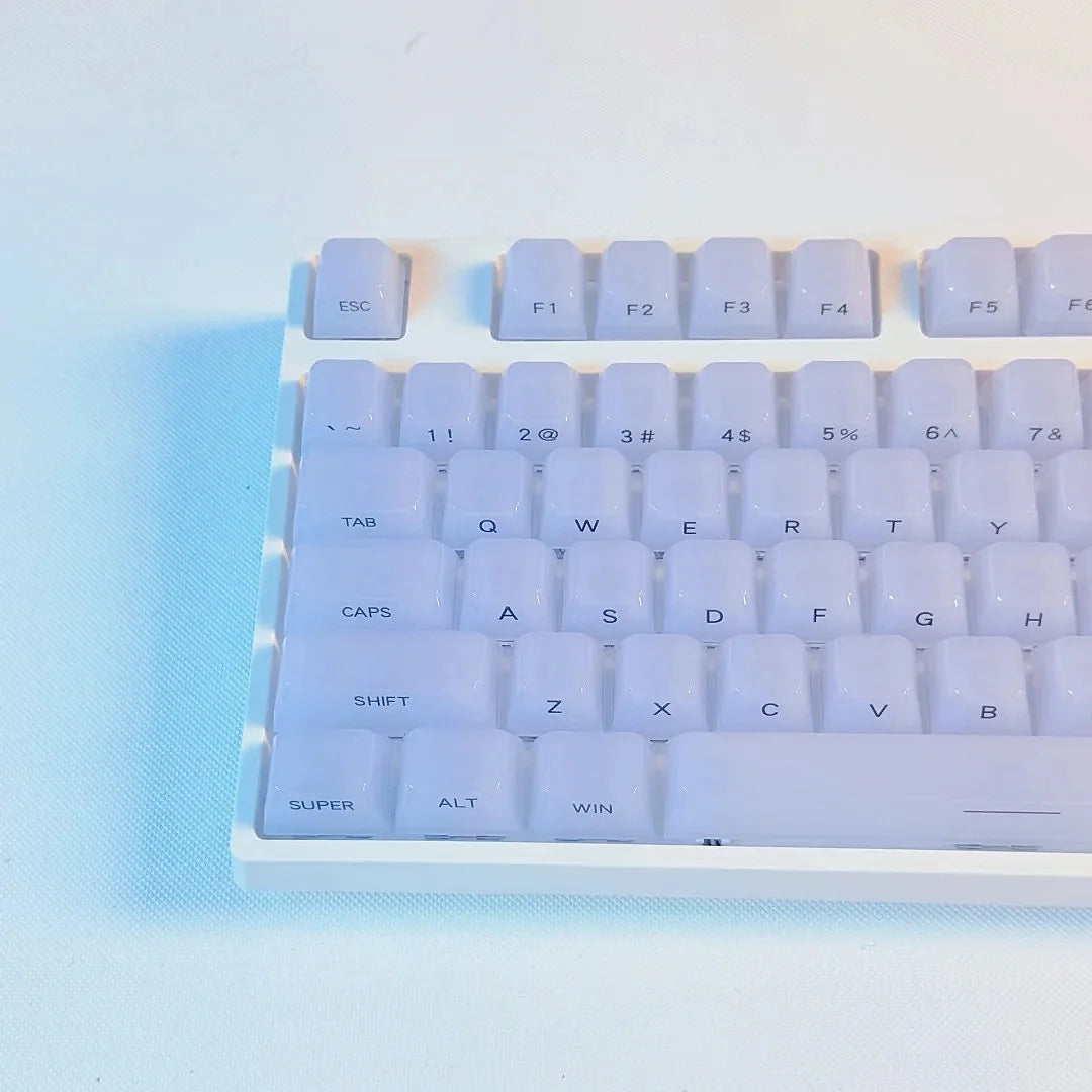 A close-up view of white custom profile keycaps for a mechanical keyboard, showing various function and alphanumeric keys.