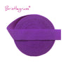 Purple Bristleglass elastic hair ties and trims rolled into a coil.