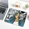 A dark illustration of a woman with long blue hair and a fierce animal face covers the surface of a mouse pad.