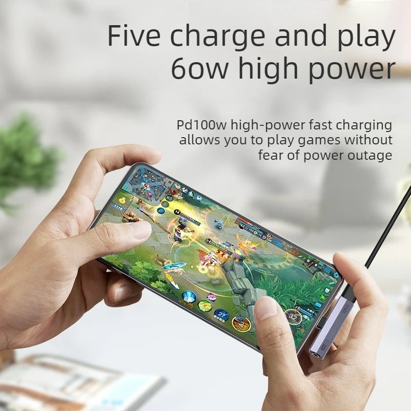 A hand holds a smartphone displaying text about fast charging and playing games, next to a USB-C to 3.5mm audio adapter.