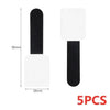 Five reusable white and black adhesive cable ties for desk organization