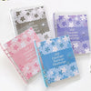 A set of transparent plastic envelopes with floral designs for a 100 envelope savings challenge planner