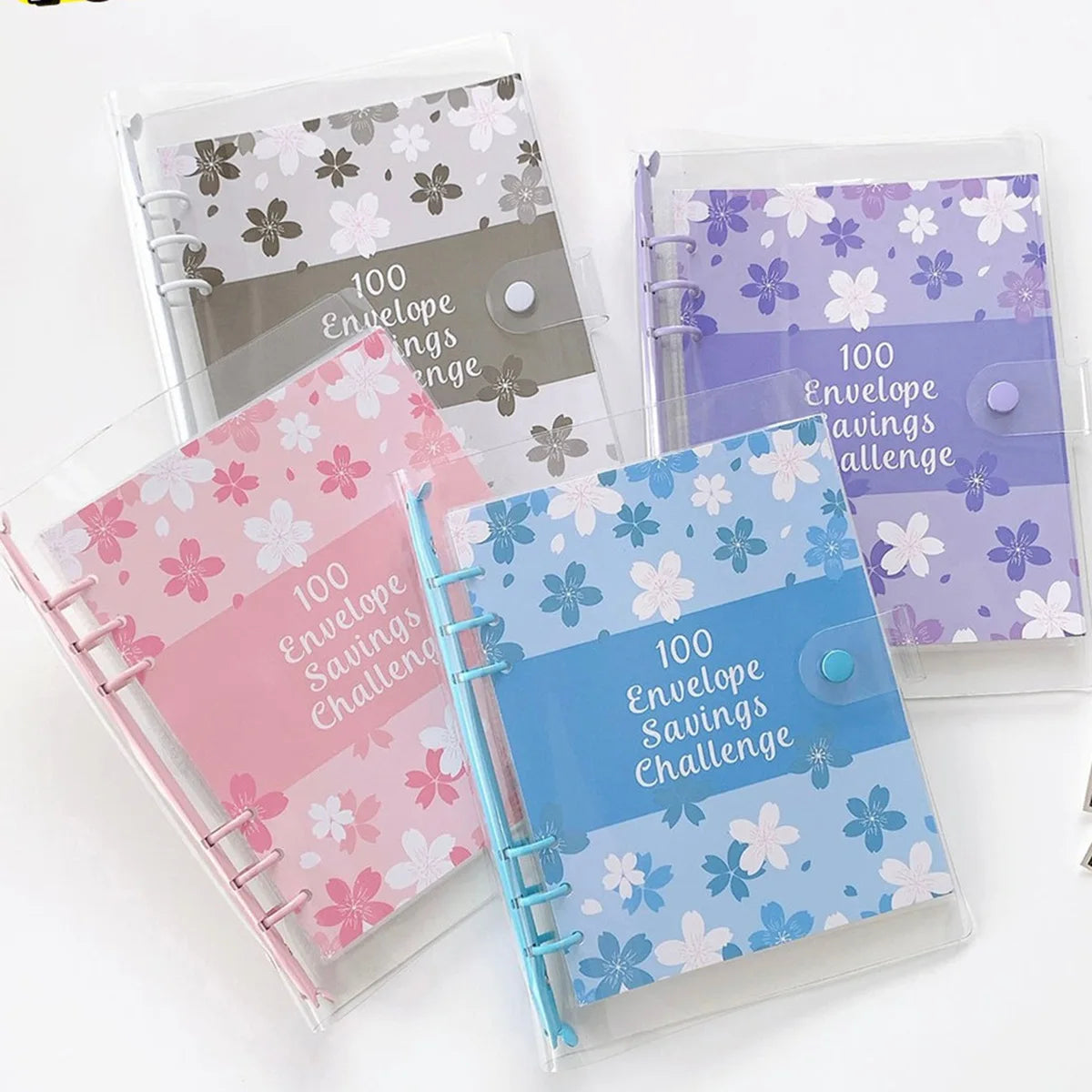 A set of transparent plastic envelopes with floral designs for a 100 envelope savings challenge planner