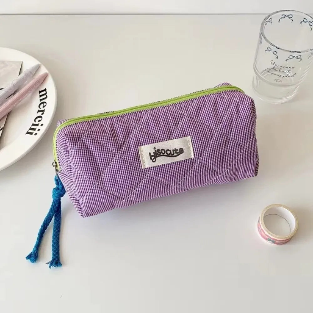 Purple checkered pencil case with a lime green trim resting on a white surface.