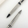 A close-up view of a premium metal ballpoint pen with a silver finish and black accents resting on a white surface.
