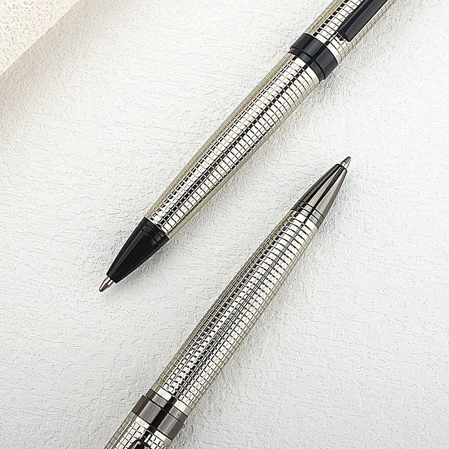 A close-up view of a premium metal ballpoint pen with a silver finish and black accents resting on a white surface.