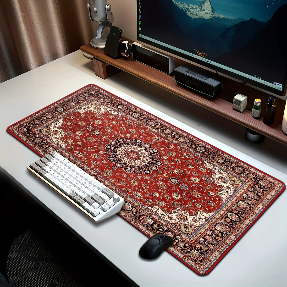 A vintage Persian rug mouse pad with a non-slip rubber base is placed on a white desk next to a computer monitor and keyboard