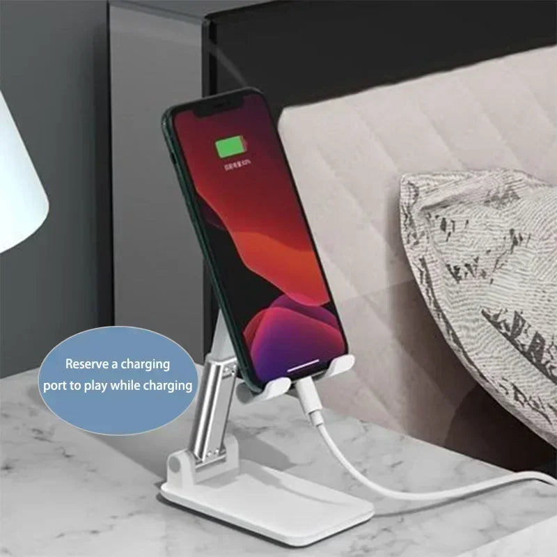 A white phone holder stand is shown next to an iPhone, designed to allow the phone to play while charging.