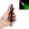 A hand holds an interactive pet training pen with a green light beam emitting from the tip.