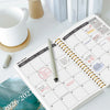 An open A5 weekly and monthly planner showing pages for January 2026 to December 2027 with ruled lines and calendar grids.