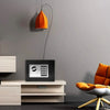 An orange pendant light hangs above a black digital lock safe box on a light wood cabinet.
