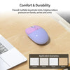 A purple gradient cat-shaped wireless mouse resting on a wooden desk next to a laptop.