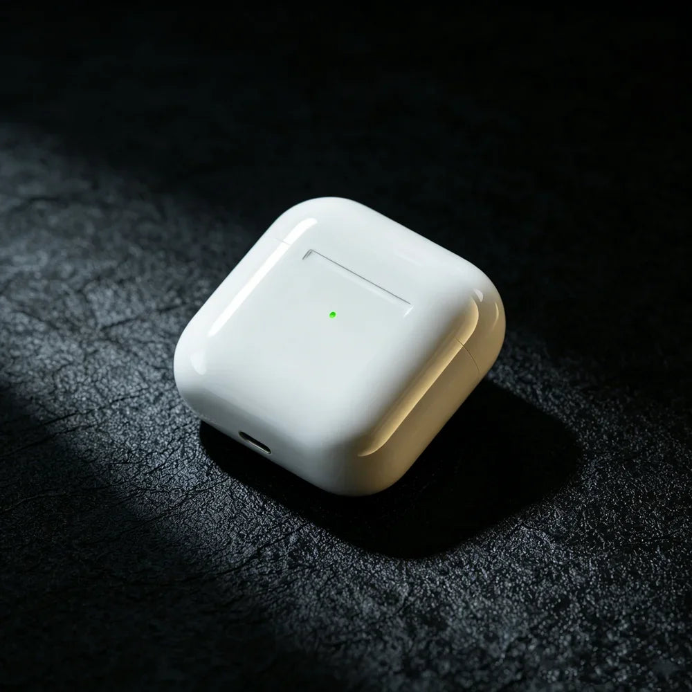 A white True Wireless Earbuds with an indicator light resting on a dark, textured surface.