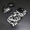 A black Apple AirPods case and a camouflage patterned phone case are displayed on a dark surface.